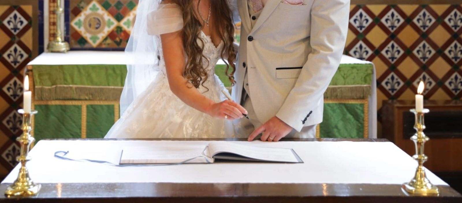 A close up detail of a wedding couple standing up signing the wedding register in St Mary church